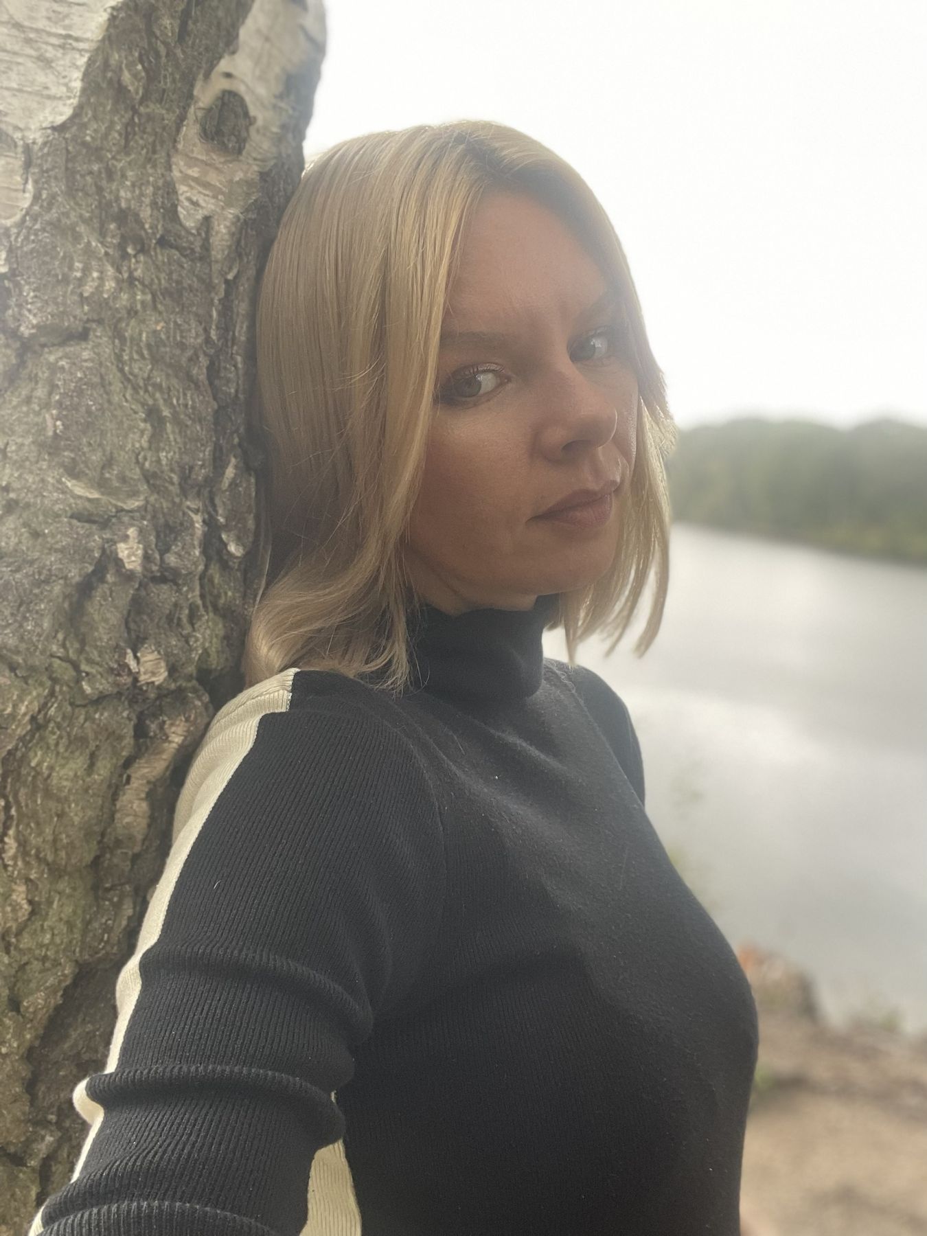 Daria an eine Birke gelehnt, im Hintergrund ein See
