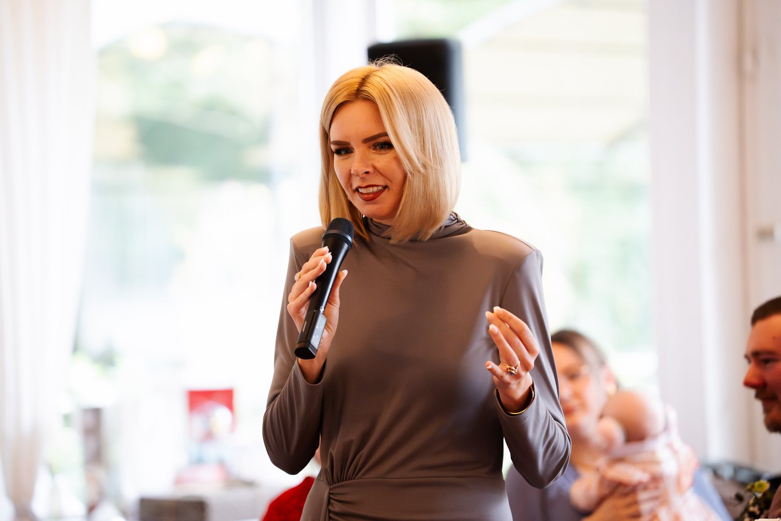 Daria Pfeiffer spricht mit Mikrofon bei einer Zeremonie in einem hellen Saal